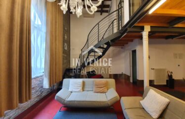 "Proponiamo in vendita nel Sestriere di Castello, a pochi passi da Via Garibaldi, splendido loft industriale, con mattoni a vista e grandi vetrate. L'intero immobile gode di luce naturale ed ha una splendida vista sul verde. Al piano rialzato si sviluppa in un'ampia zona living in uno spazio a tutta altezza, dove si trova i mattoni a vista tipici del loft e le travi a view tipiche di Venezia. La zona giorno e 'illuminata da una grande finestra ad arco che affaccia sul verde; troviamo sempre al piano un bagno con doccia finestrato. Al piano primo si sviluppa la zona notte con due camere, di cui una matrimoniale ed una singola, un particolarissimo bagno. Ogni angolo della casa e dell'arredamento è stato creato e pensato per rendere unica la soluzione. Può diventare una casa residenziale, ma anche una seconda casa o come investimento. ". loft design porta sola venice venezia real estate sell buy apartment