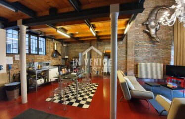 "Proponiamo in vendita nel Sestriere di Castello, a pochi passi da Via Garibaldi, splendido loft industriale, con mattoni a vista e grandi vetrate. L'intero immobile gode di luce naturale ed ha una splendida vista sul verde. Al piano rialzato si sviluppa in un'ampia zona living in uno spazio a tutta altezza, dove si trova i mattoni a vista tipici del loft e le travi a view tipiche di Venezia. La zona giorno e 'illuminata da una grande finestra ad arco che affaccia sul verde; troviamo sempre al piano un bagno con doccia finestrato. Al piano primo si sviluppa la zona notte con due camere, di cui una matrimoniale ed una singola, un particolarissimo bagno. Ogni angolo della casa e dell'arredamento è stato creato e pensato per rendere unica la soluzione. Può diventare una casa residenziale, ma anche una seconda casa o come investimento. ". loft design porta sola venice venezia real estate sell buy apartment
